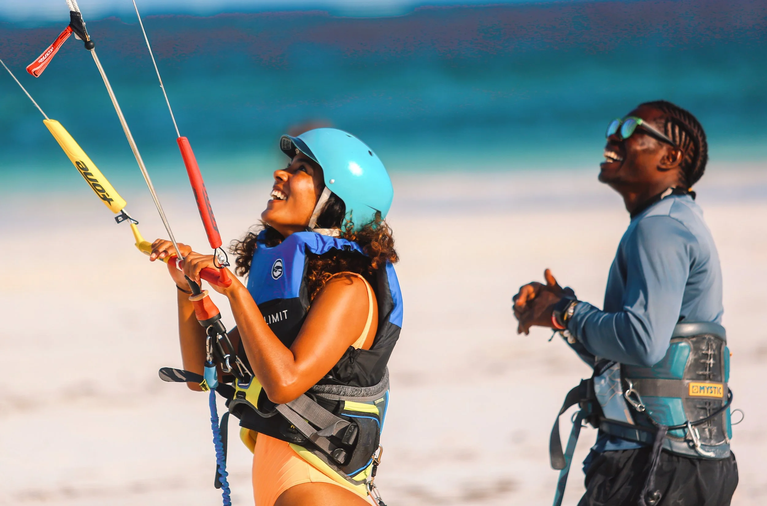 A guest smiling while rigging her kite on the beach