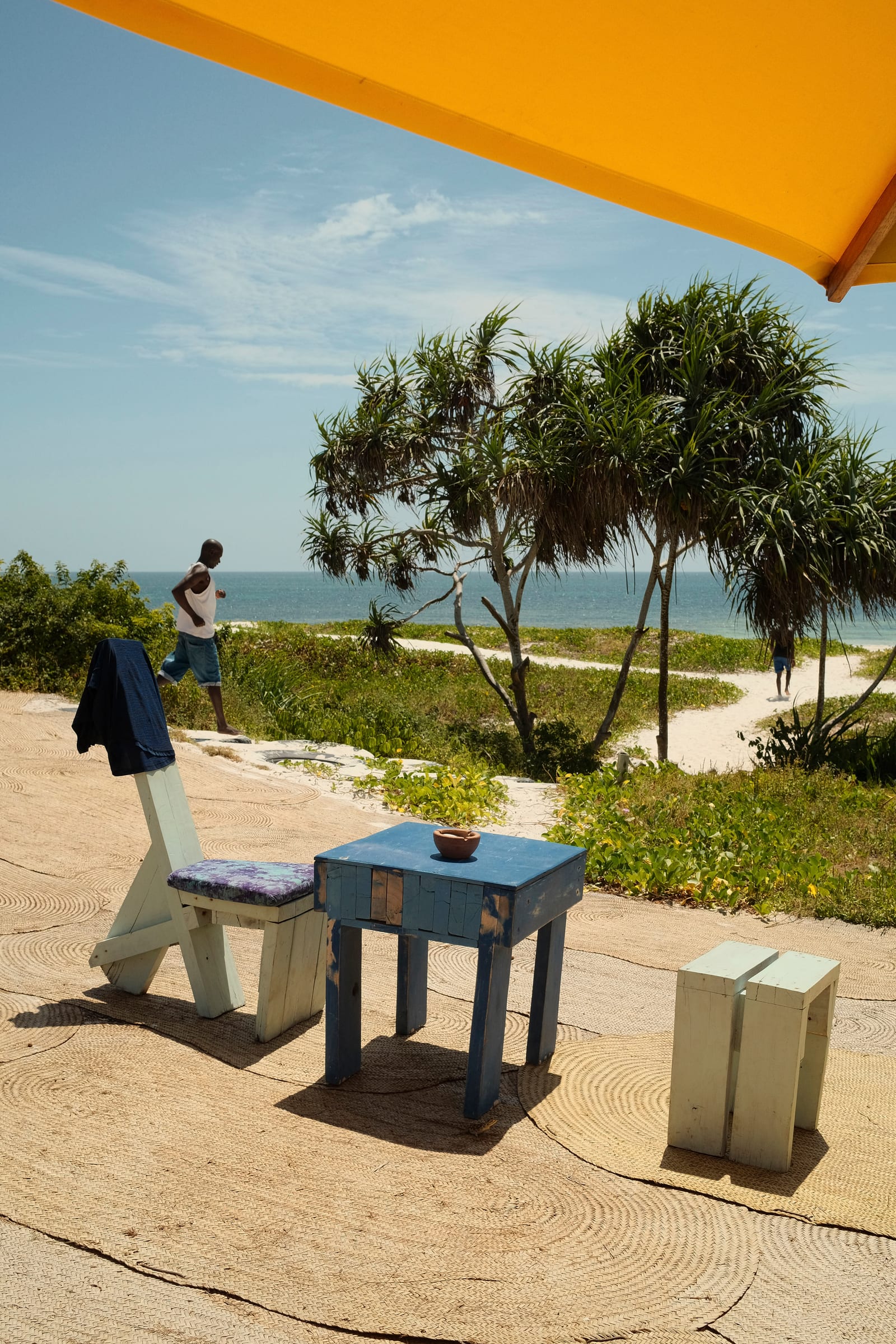 Beachside seating under a yellow umbrella at Salty's Kitesurf Village