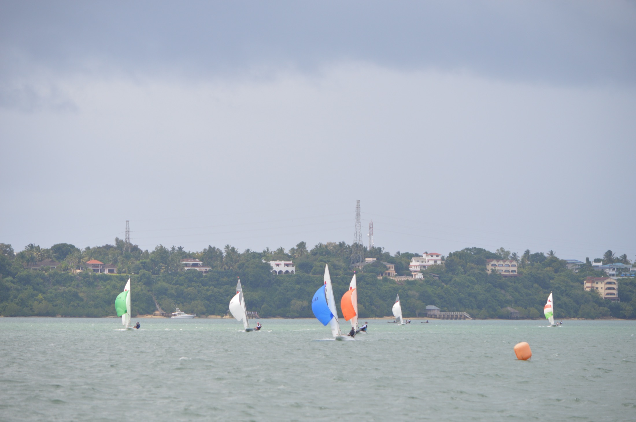 Fireball fleet reaching across Kilifi Creek with spinnakers flying