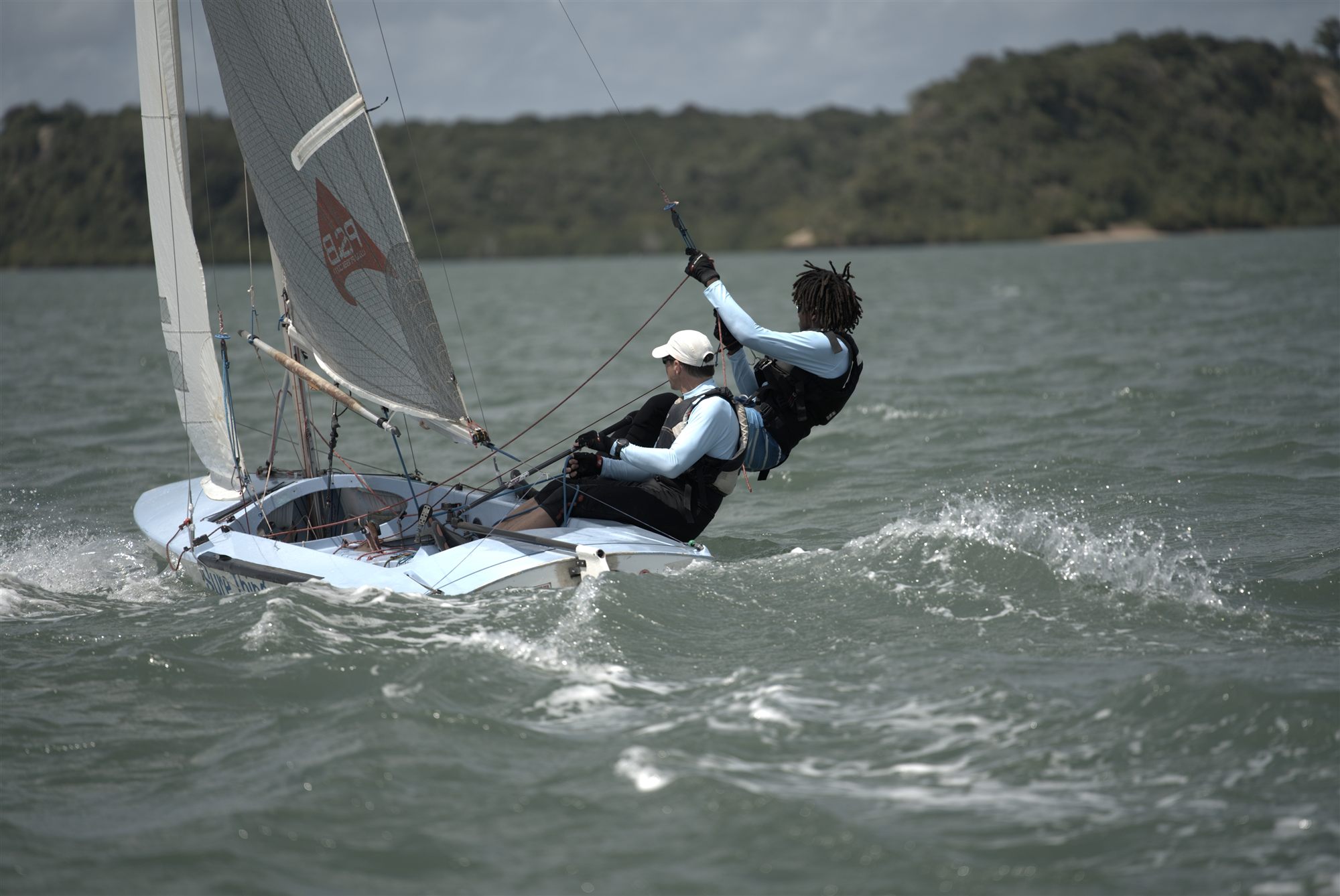 A Fireball crew hiking hard, hand on the mainsheet